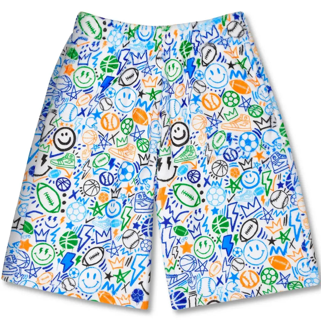Corey Paige Let's Go Sports plush board shorts with colorful all-over print featuring basketballs, soccer balls, footballs, smiley faces, stars, and crowns in blue, green, orange, and black on white fabric