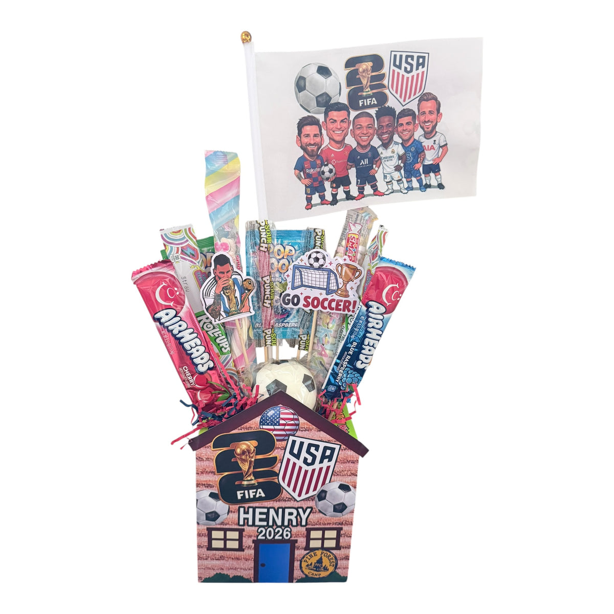 Close-up of World Cup candy cabin showing personalized brick house base with Henry 2026, FIFA trophy, USA Soccer logo, soccer ball decorations, and colorful candy arrangements