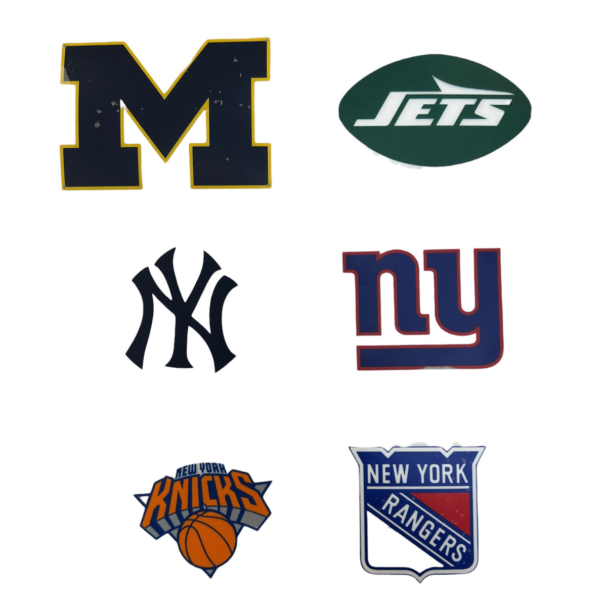 Sheet of sports team hat patches including Michigan M, Jets, Yankees, Giants, Knicks and Rangers logos