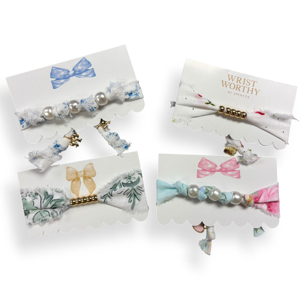 Four classic coquette bracelets with pearl and gold beads on blue, green, pink and floral fabric