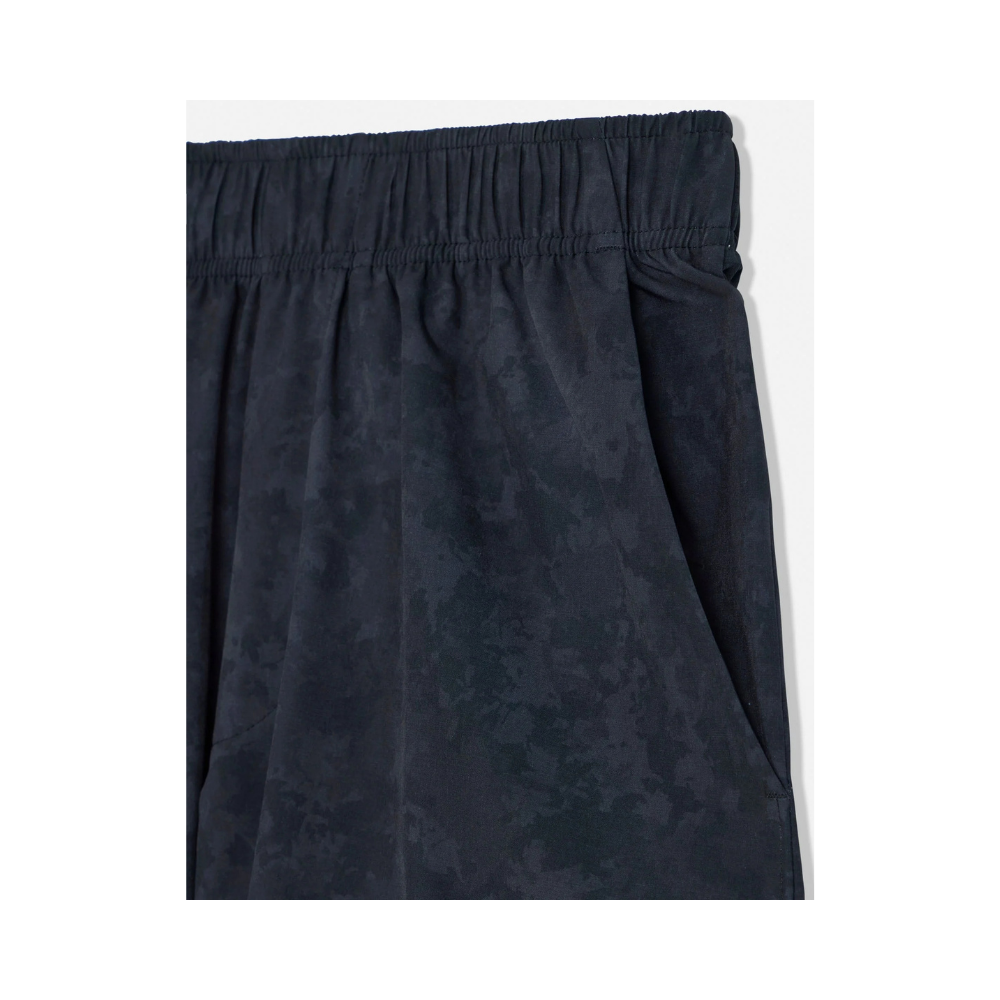 Close-up of navy camo athletic shorts showing elastic waistband detail and gathered fabric texture with mottled print