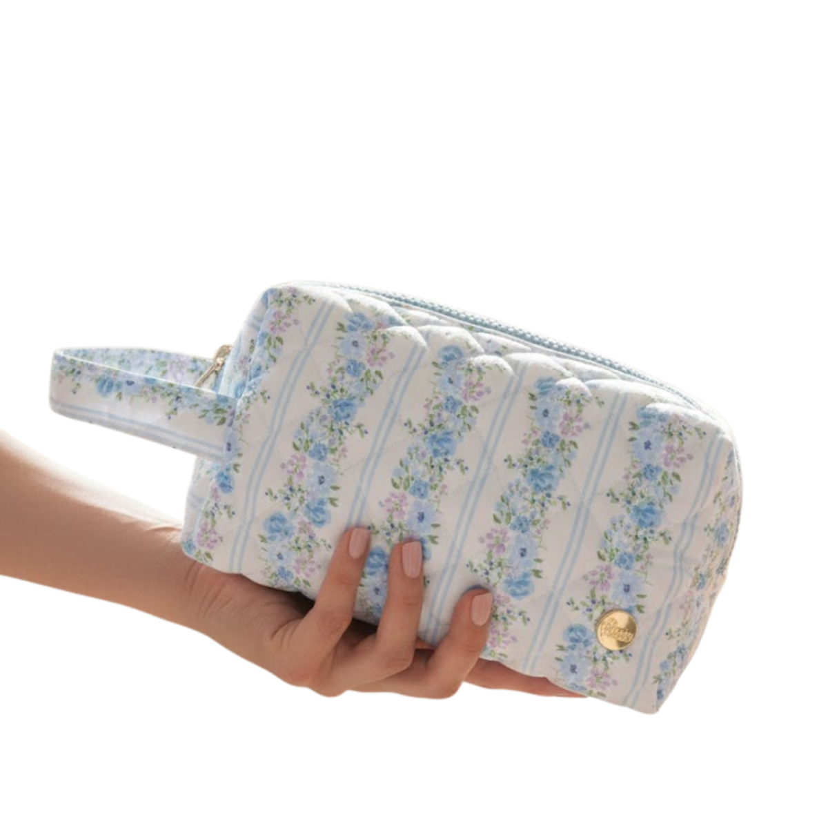 Hand holding a blue striped floral quilted cosmetic pouch