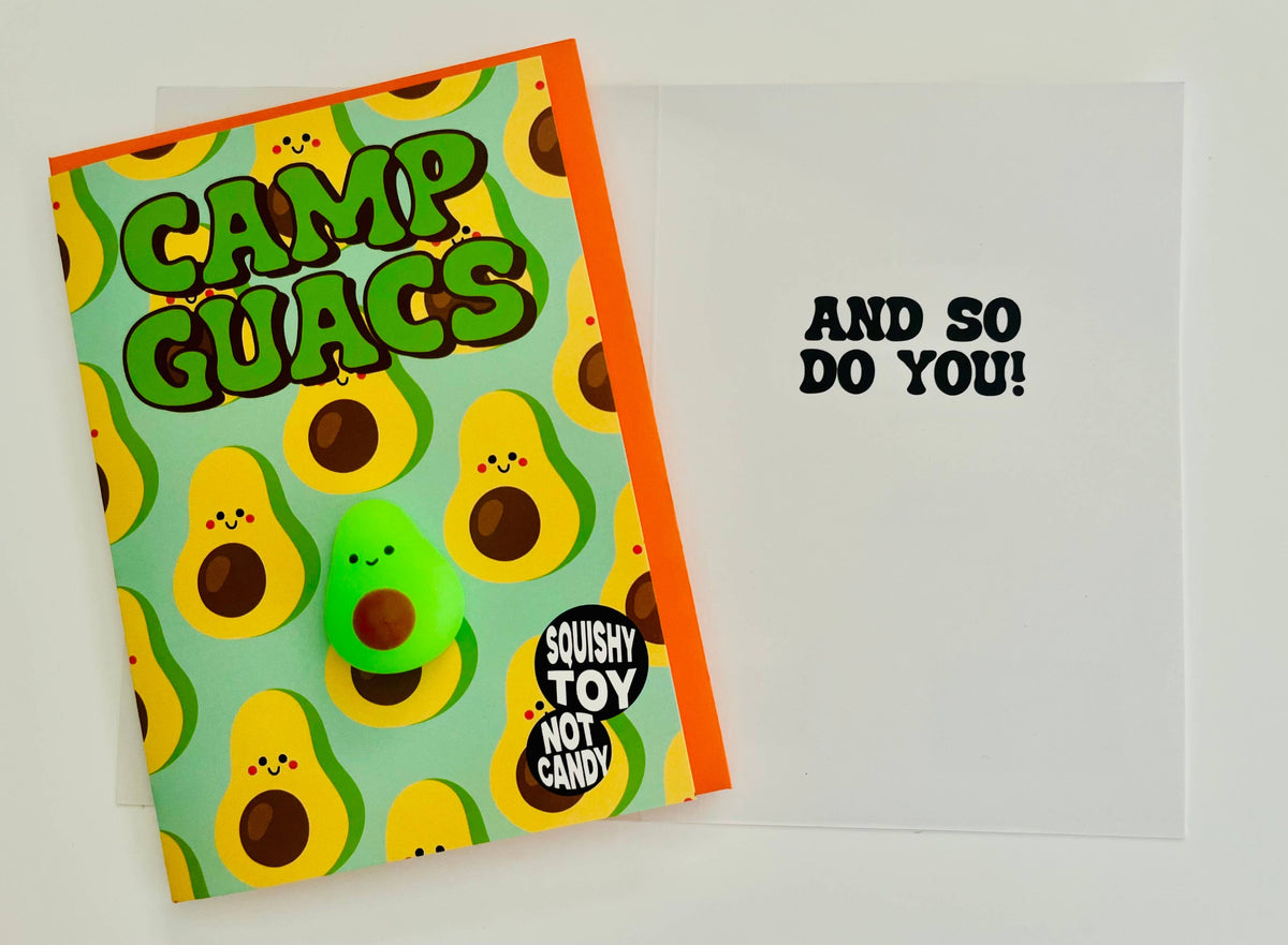 Camp Guacs 5x7 greeting card flat lay showing avocado pattern with smiling faces, bright orange envelope, mini green avocado squishy positioned on white card with And So Do You message