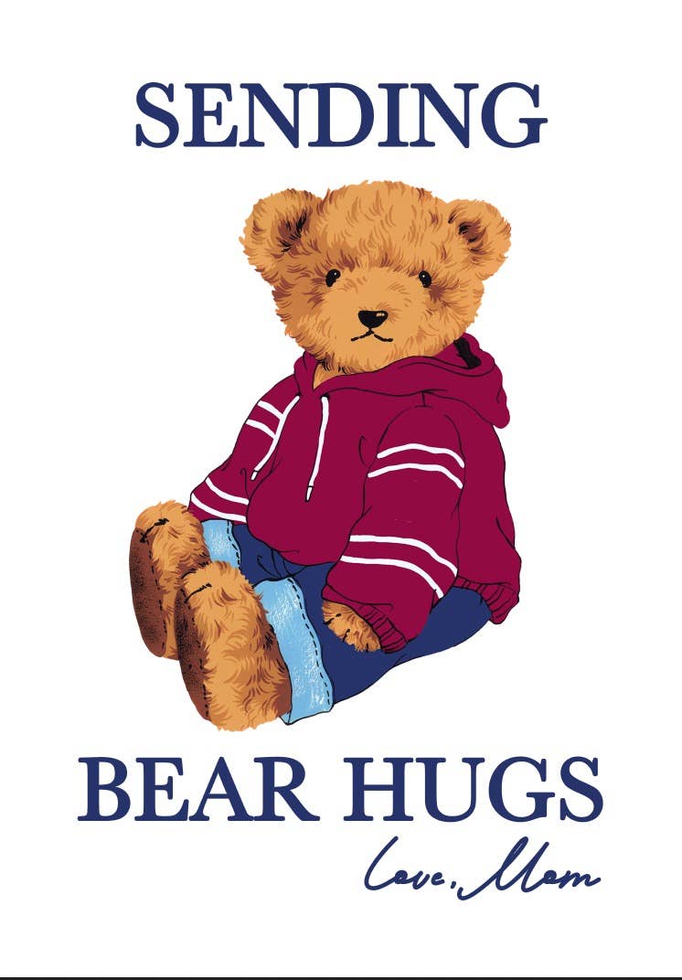 Close up of Sending Bear Hugs card featuring illustrated brown teddy bear wearing maroon hoodie with white stripes sitting on white card