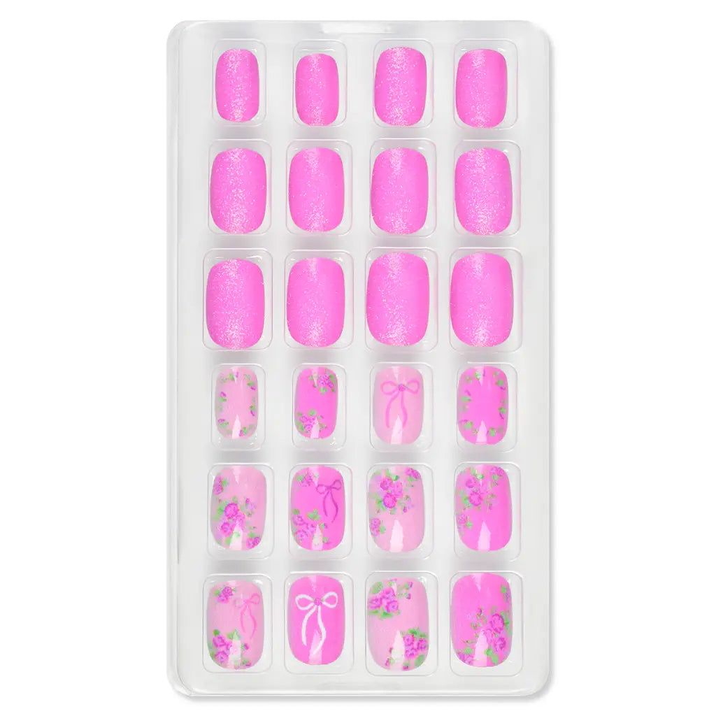 Pretty in Pink press-on nail set in a tray, with glittery hot pink nails and pink nails with floral and bow designs