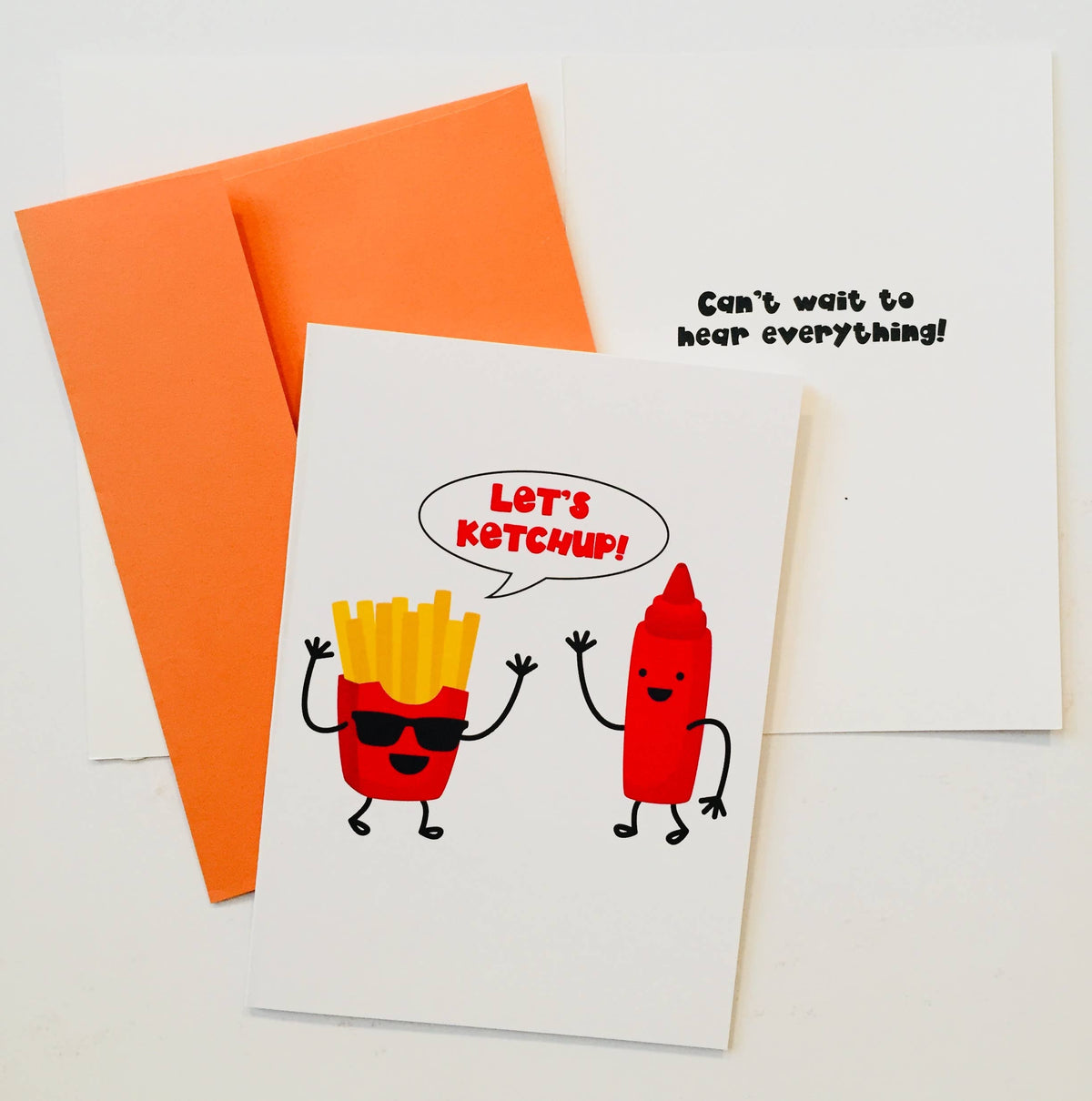 Let's Ketchup greeting card with cartoon french fries wearing sunglasses and red ketchup bottle on white card with orange envelope