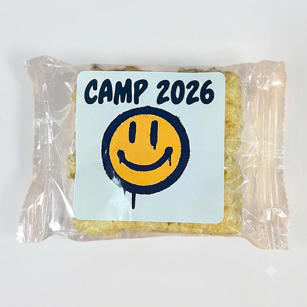 Rice Krispies treat with a CAMP 2026 label showing a navy and yellow drippy smiley face