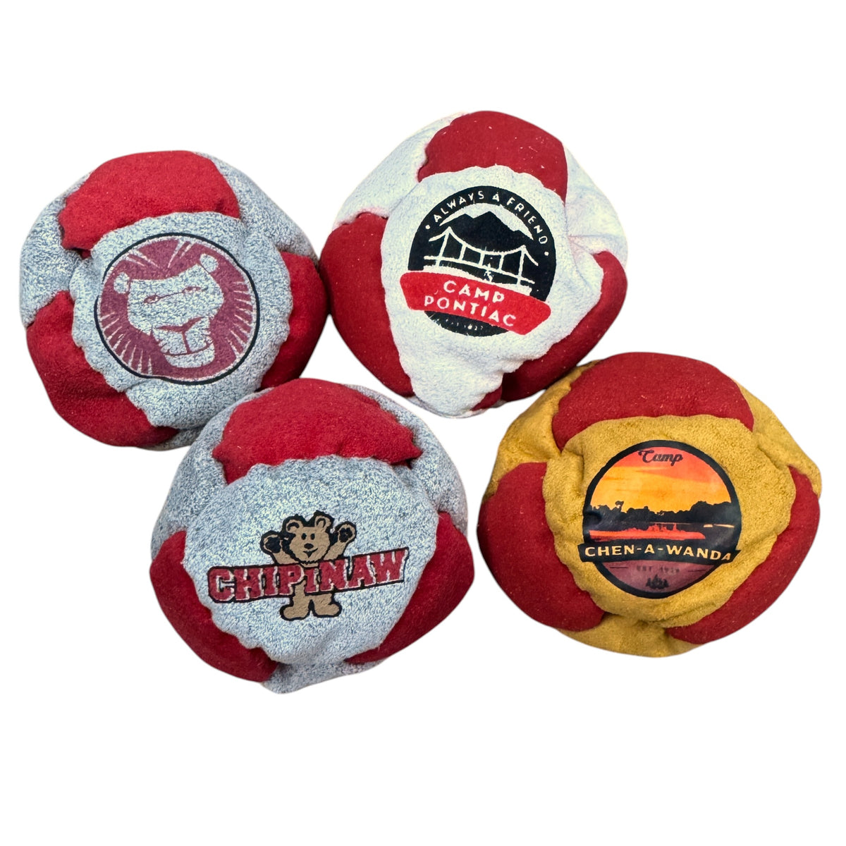 Close-up of Timber Lake Camp hacky sack displaying tiger face logo in green on beige background