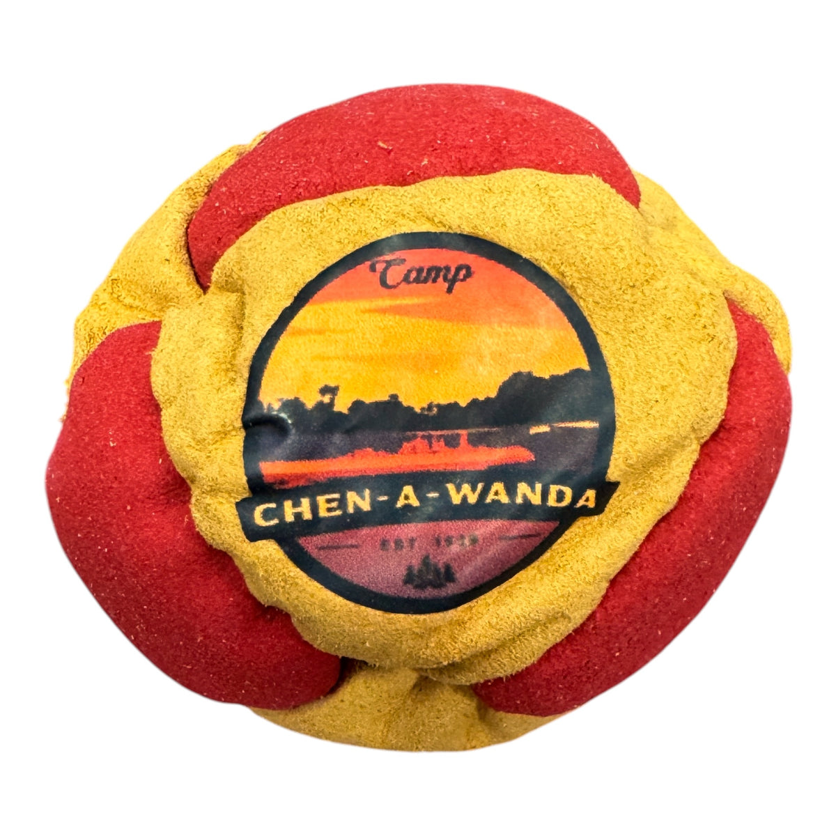 Close-up of Camp Taconic hacky sack showing mountain and sun logo on green and beige fabric
