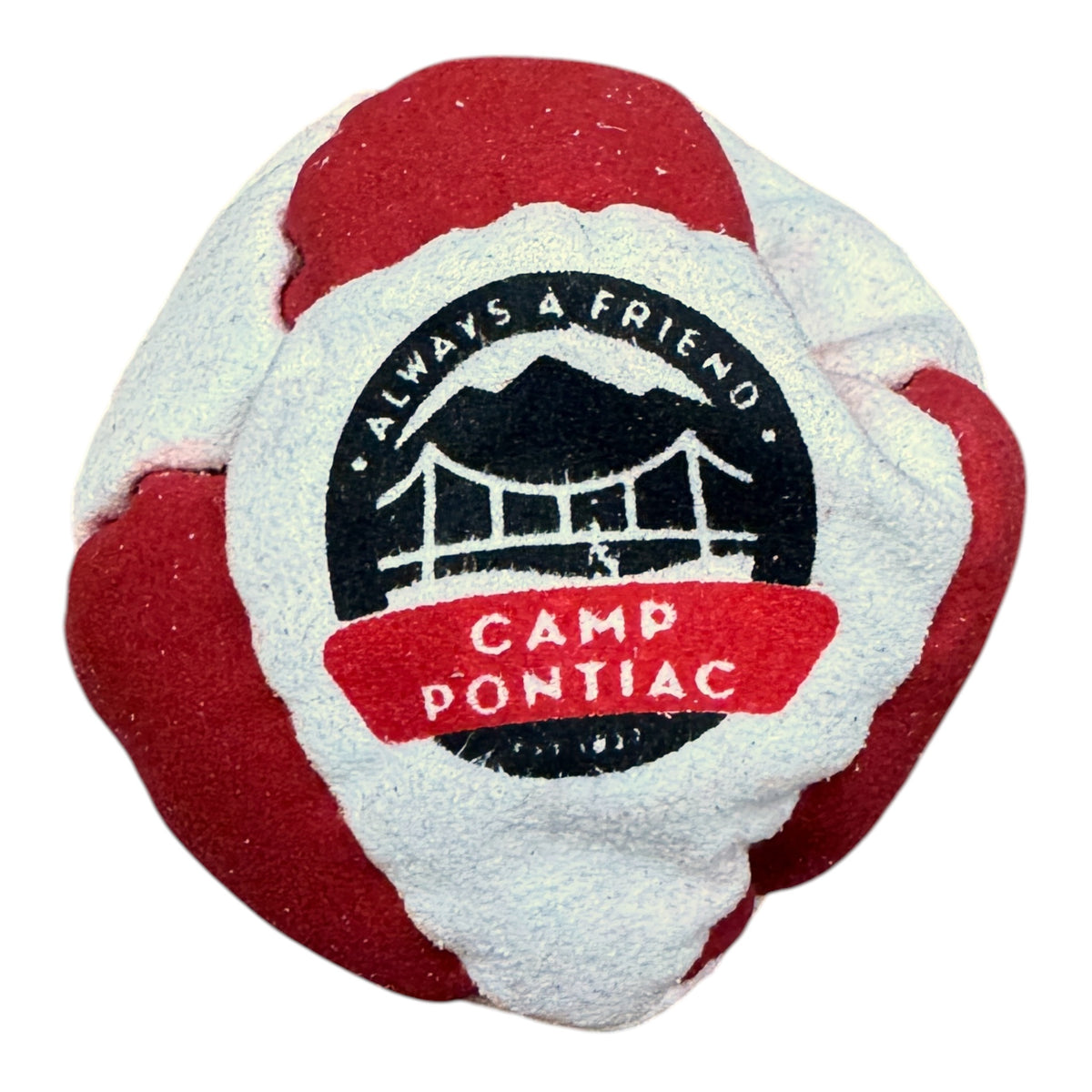 Close-up of Camp Pontiac hacky sack in red and beige with cabin logo and CAMP A FRIEND text