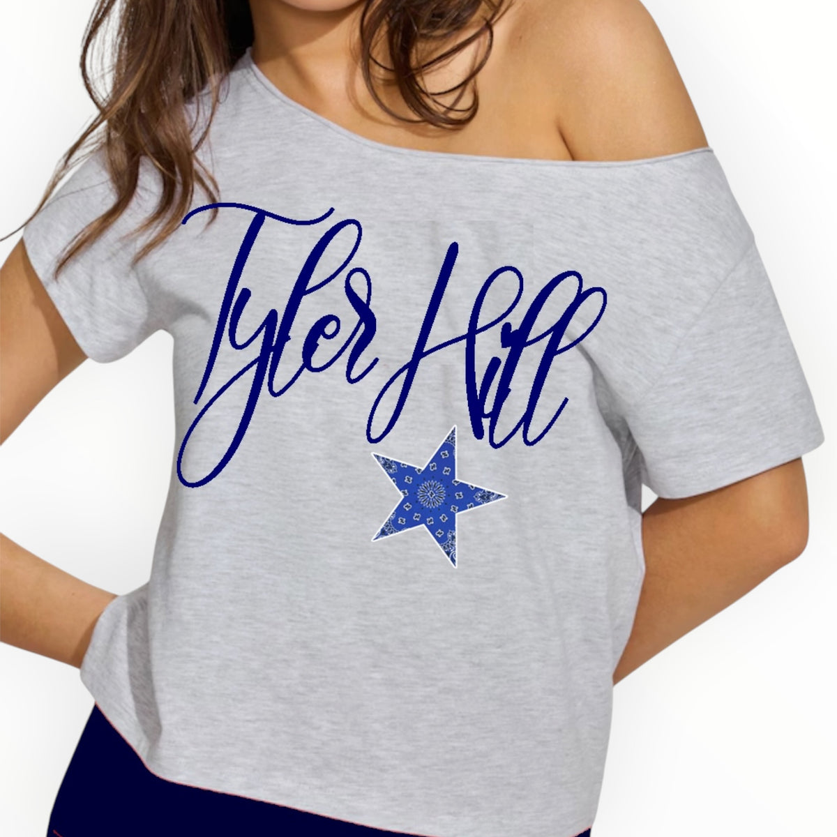 Off-shoulder cropped camp shirt featuring Tyler Hill name in blue script with blue bandana star detail