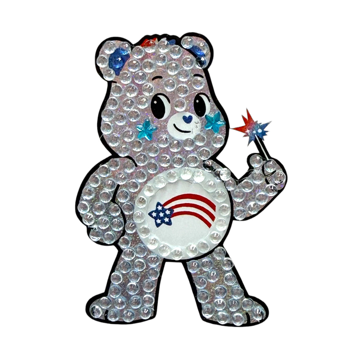 America Cares Stickerbean featuring a sparkly clear rhinestone bear with red and blue accents, blue star earrings, holding a patriotic star wand with red white and blue stars, and an American flag shooting star design on white belly