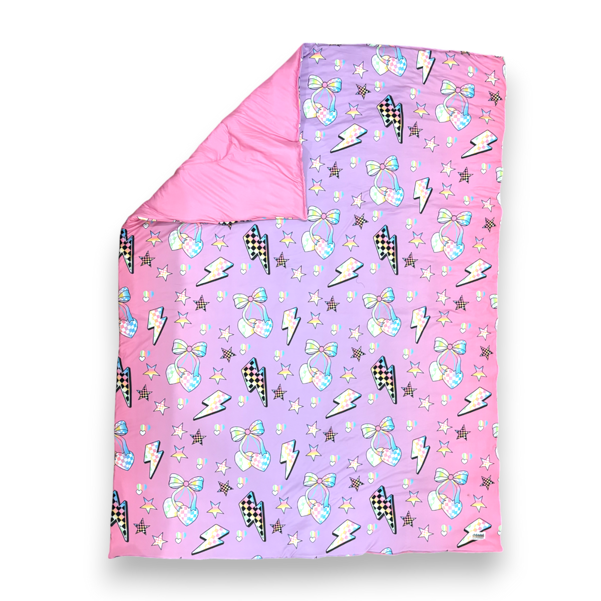 Colorful patterned blanket with stars, bows, and lightning bolts on a pink and purple gradient background. electric-cherry-check-comforter