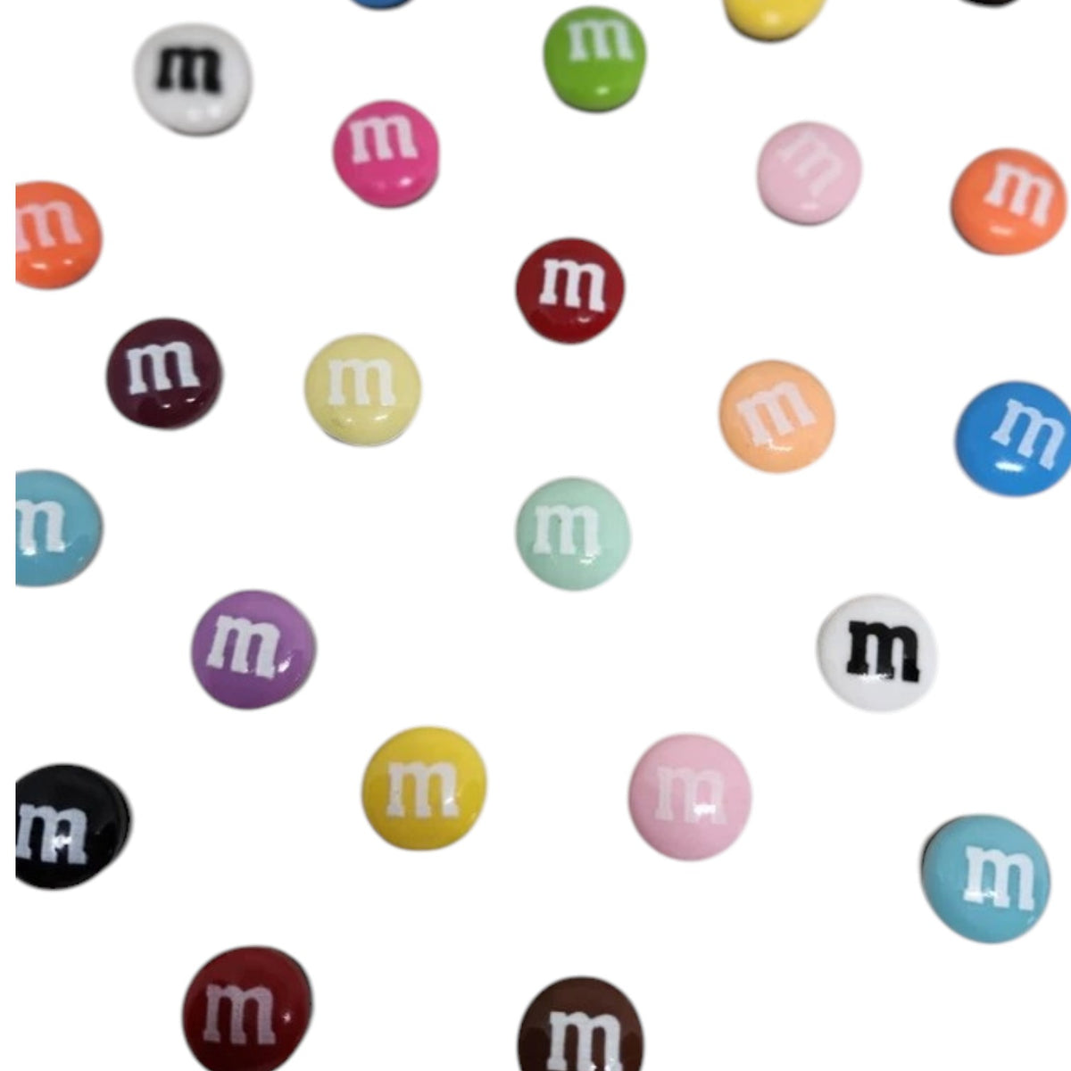 Assorted colorful M&M-style shoe charms with a white m on each