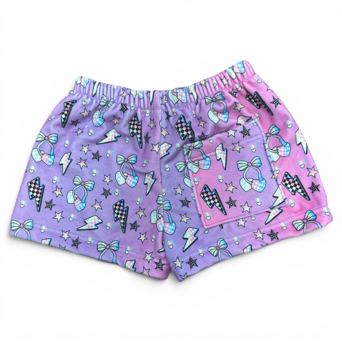 Back view of Electric Cherry Fuzzy Shorts showing pink and purple ombre gradient with checkered lightning bolt pattern, cherries, stars and functional back pocket