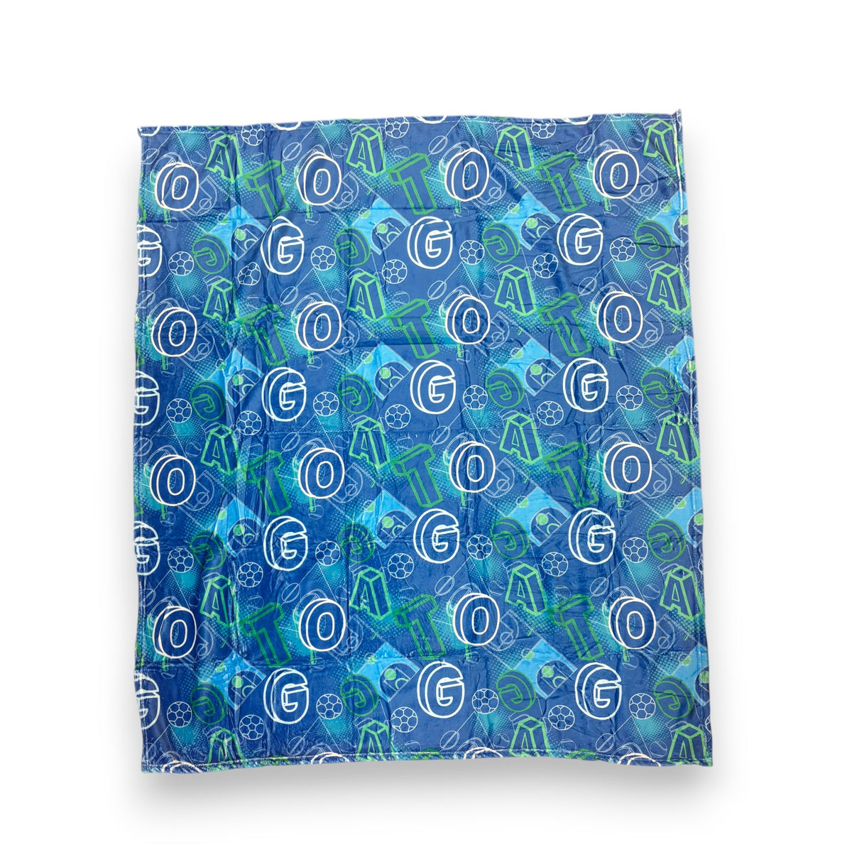 G.O.A.T. fuzzy camp blanket in blue and green with GOAT letters and sports balls