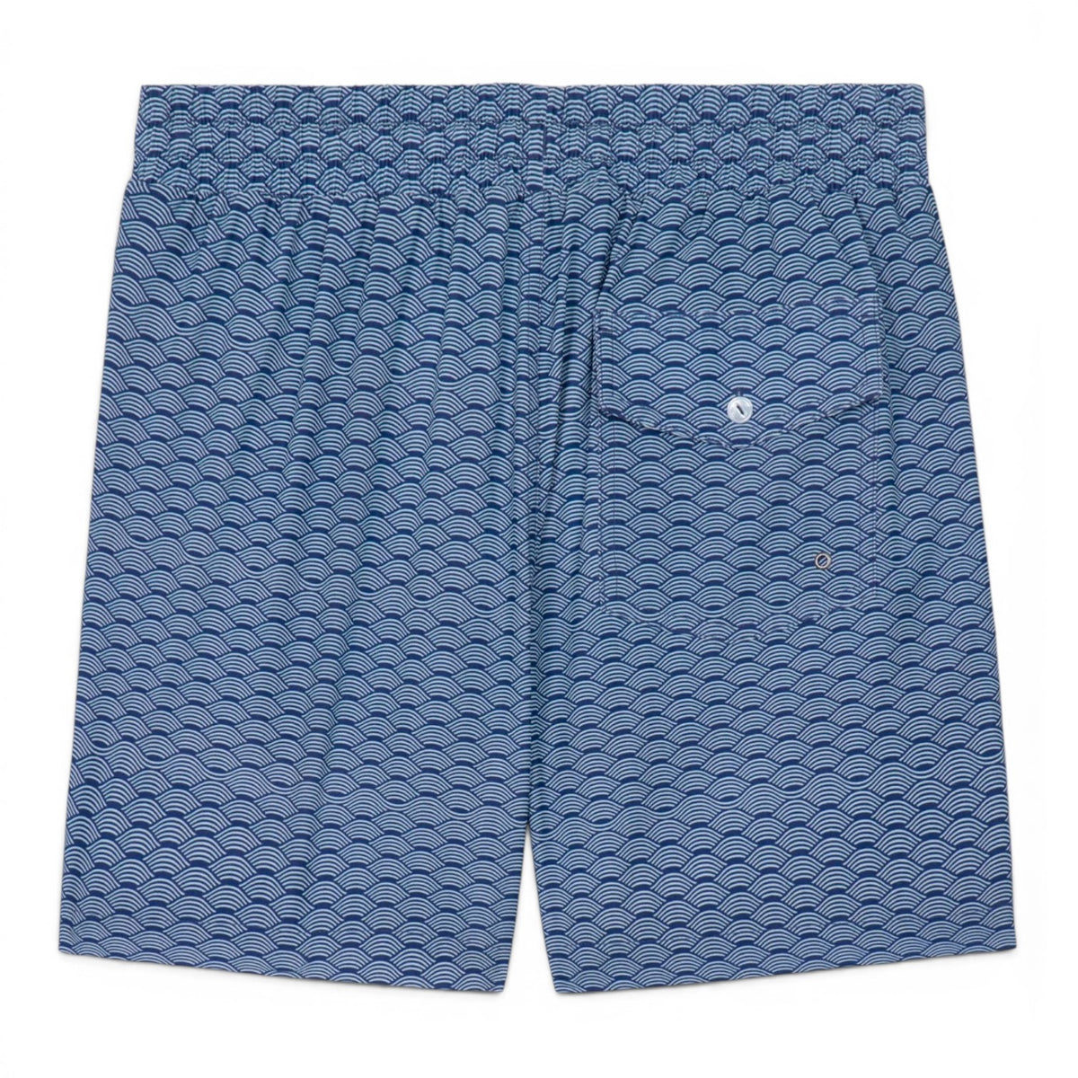 Back view of GOAT Wave swim trunks showing navy blue fabric with repeating white wave pattern and small logo detail